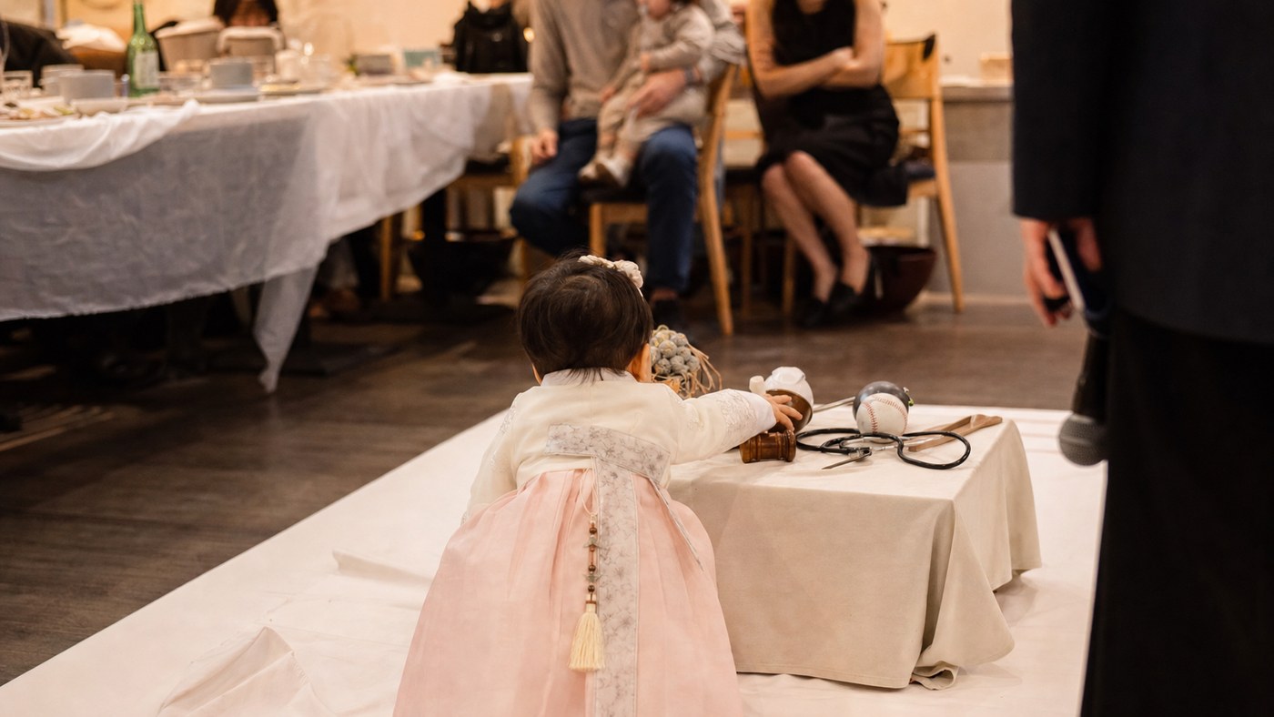 Candid doljabi moment with a child reaching toward objects while adults watch softly out of focus